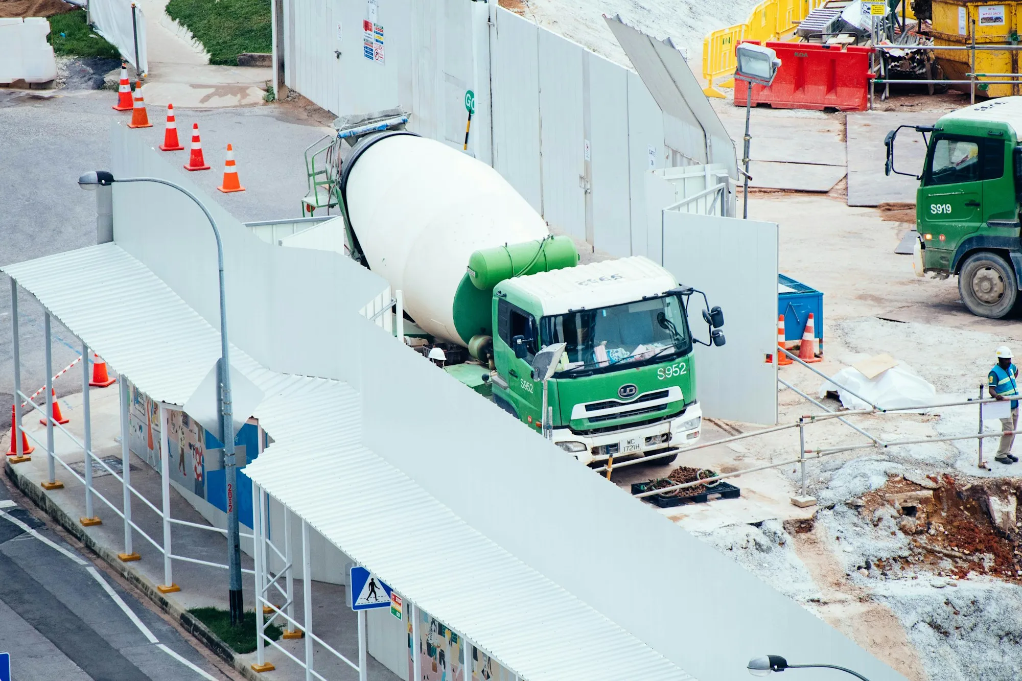 Şantiyede duran yeşil beyaz beton mikseri